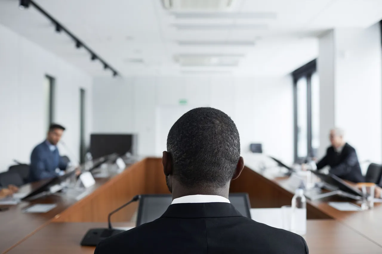 Candidat de dos face à deux recruteurs dans une salle de réunion